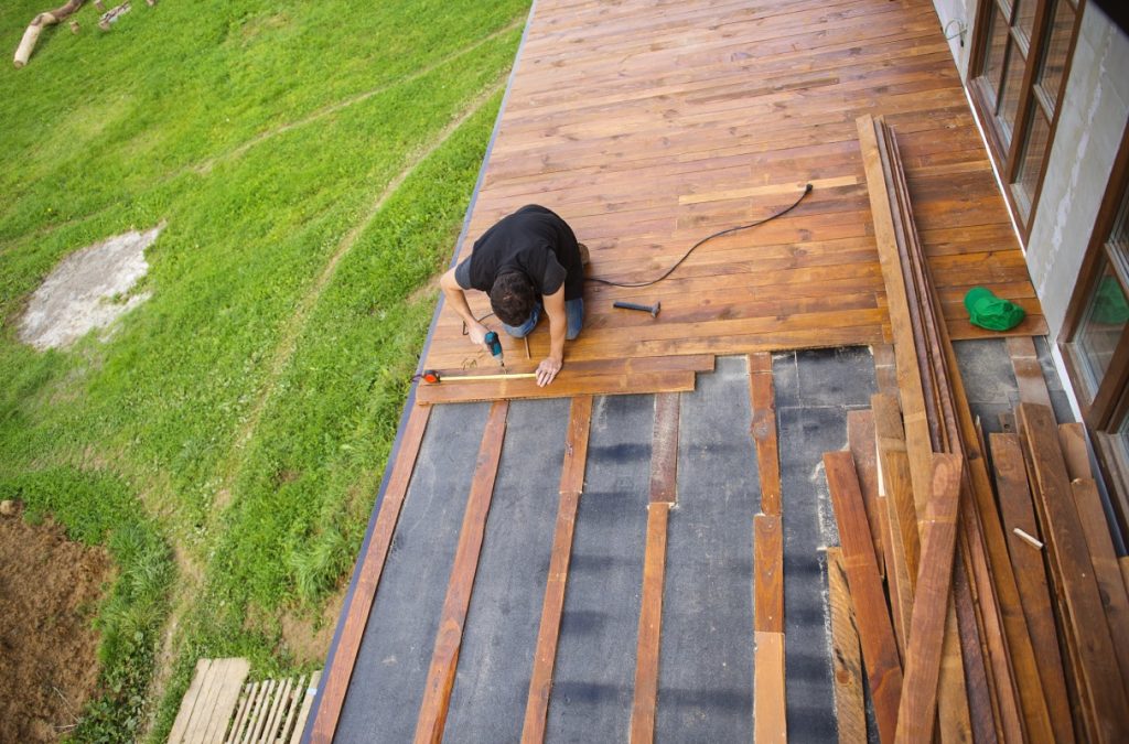 Persona instalando un parquet en el exterior