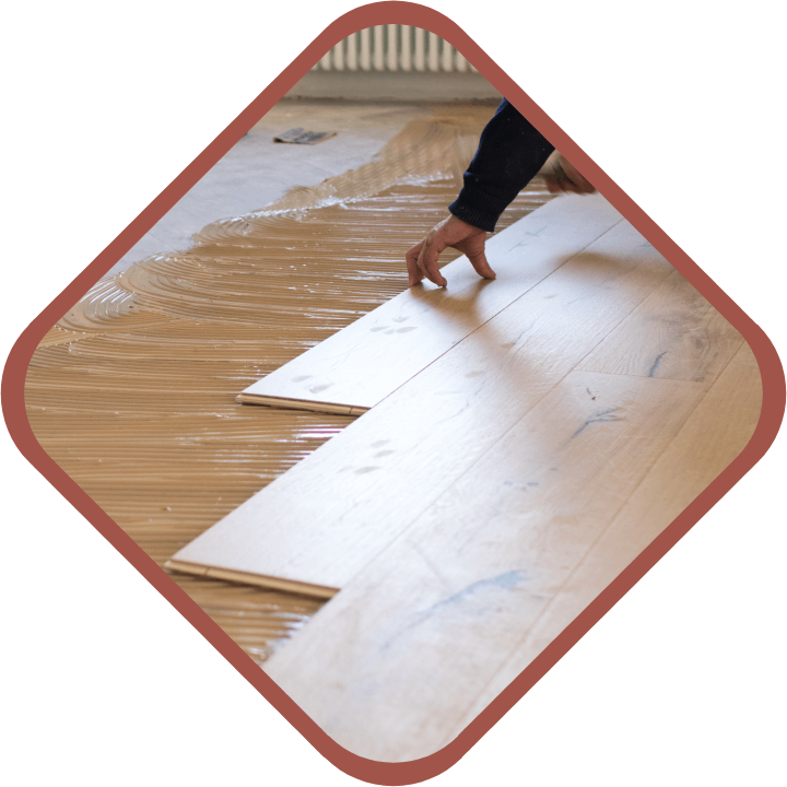 Persona instalando parquet en una casa