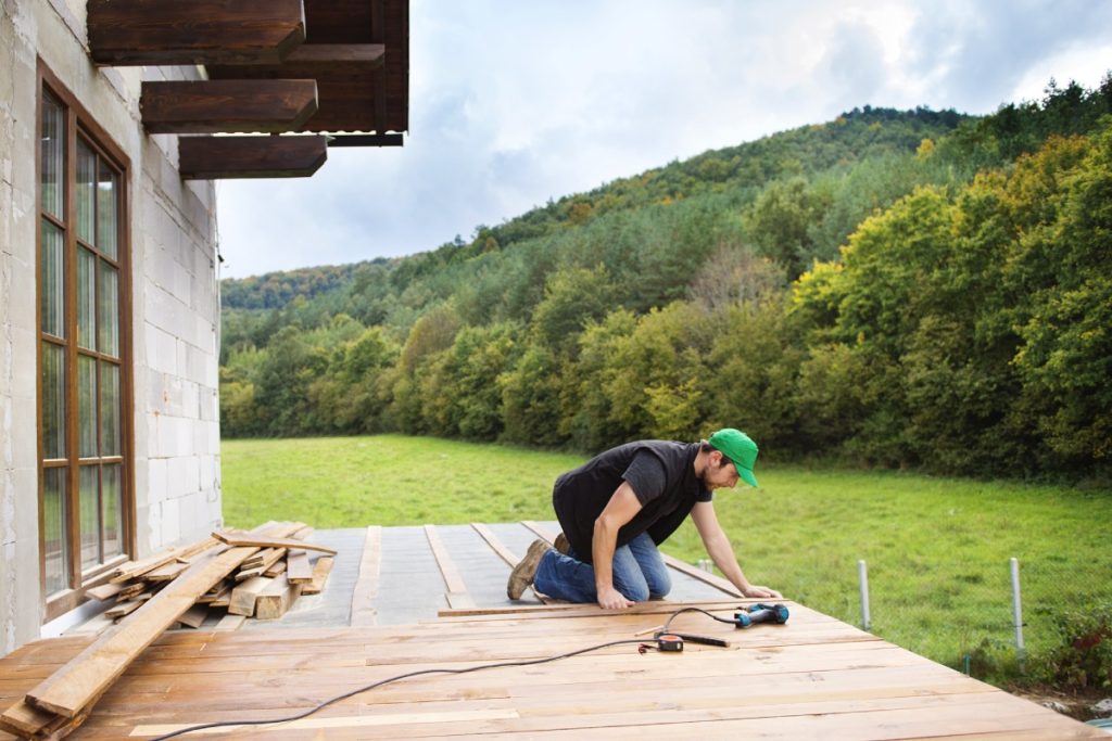 Persona instalando un parquet en el exterior